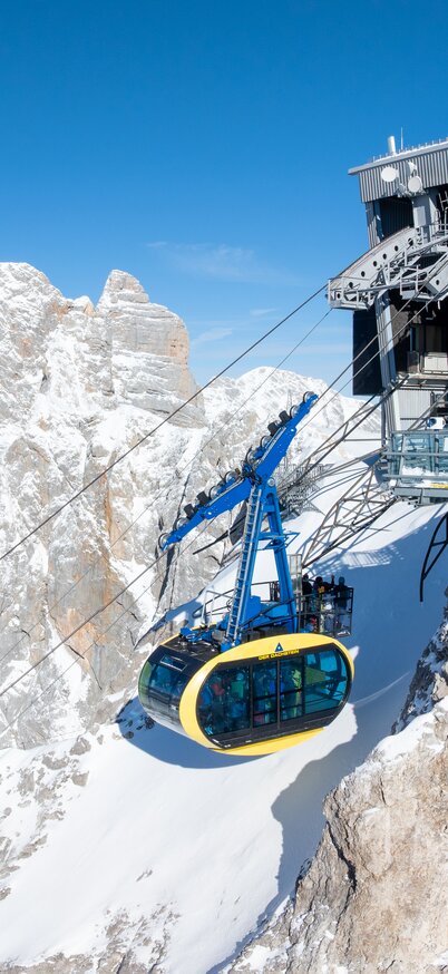 Blick auf das Dachsteinpanorama mit der Dachstein-Gletscherbahn und der Dachstein-Bergstation am Dachstein Gletscher. | © Josh Absenger