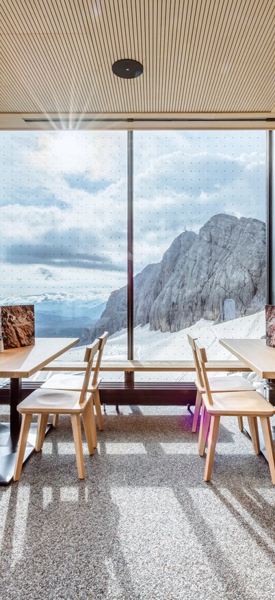 Moderne Restaurant-Einrichtung mit Blick auf majestätische Berge. | © Christoph Huber