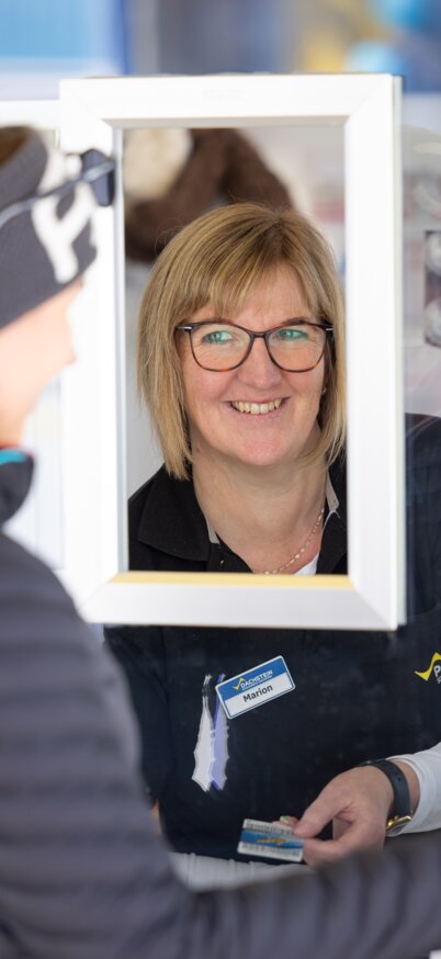 Eine freundliche Frau lächelt am Ticketschalter.  | © Harald Steiner
