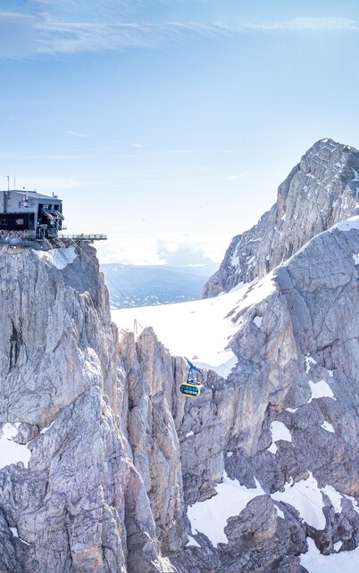 Panoramablick auf die Dachstein-Gletscherbahn und die markante Bergstation auf dem schneebedeckten Berg | © Josh Absenger