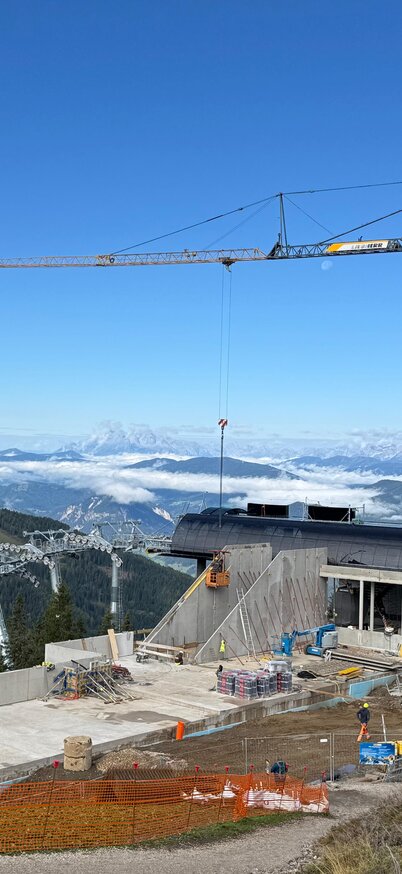 Senderbahn Bergstation am Hauser Kaibling mit Blick ins Ennstal | © Hauser Kaibling Gesamtansicht der neuen Bergstation mit Baukran, Seilbahntechnik und umliegenden Bergen, orange Absperrung im Vordergrund. | © Hauser Kaibling
