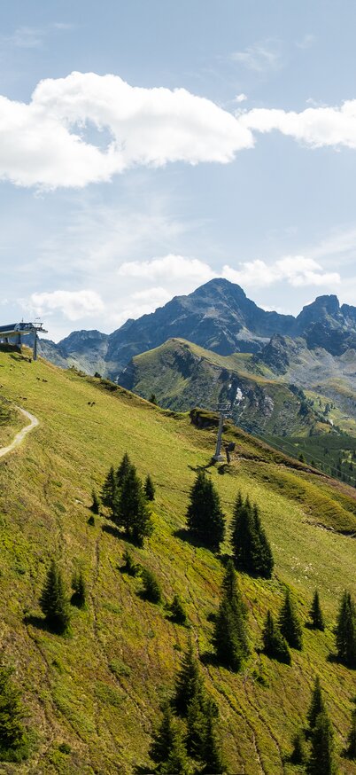 Höhenwanderweg am Hauser Kaibling mit Bergpanorama und blauem Himmel. | © Josh Absenger