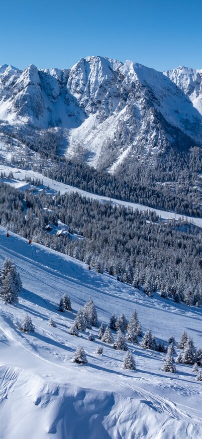 Winterpanorama Hauser Kaibling – verschneite Berge und Pisten der 4-Berge-Skischaukel Schladming-Dachstein | © Josh Absenger Panoramabild von Gipfelbahn Hauser Kaibling mit Panoramaabfahrt im Winter mit viel Sonnenschein. | © Josh Absenger