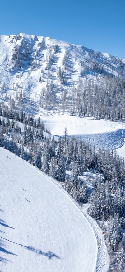 Höfi Abfahrt bei Sonnenschein mit Sender und Osthang im Hintergrund - Standort Skigebiet Hauser Kaibling. | © Josh Absenger