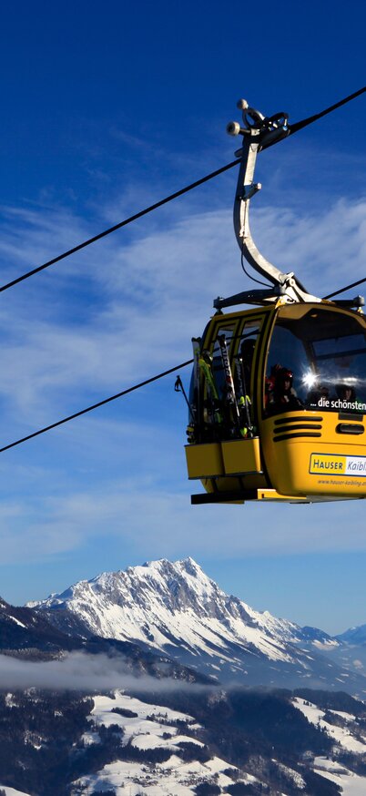 Gelbe Gondeln der Hauser Kaibling Seilbahn schweben vor beeindruckender Bergkulisse über das Ennstal. | © Hauser Kaibling