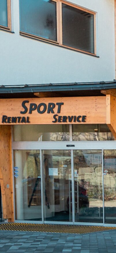 Außenansicht des Eingangs zum Sportshop Hauser Kaibling mit moderner Glasfassade und Holzdesign.