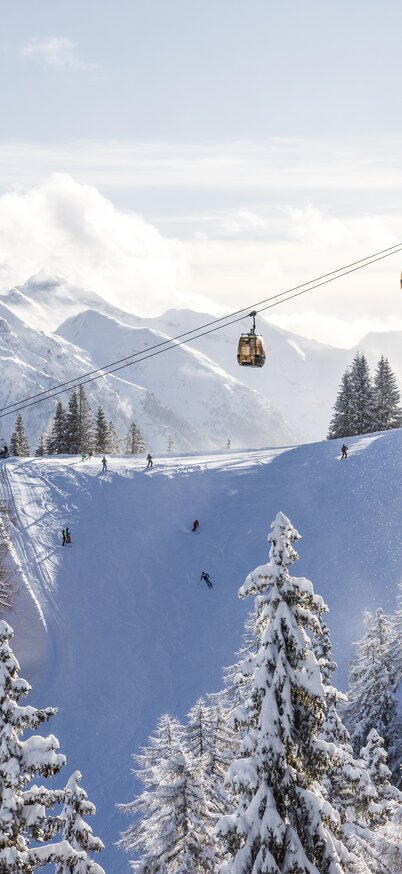 Die Gipfelbahn Hochwurzen und die Piste Nummer 33 Ostabfahrt mit Blick in die Schladminger Tauern bei Neuschnee und Sonnenschein | © Martin Huber