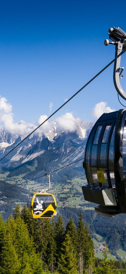 Die Planai Hauptseilbahn im Sommerbetrieb - im Hintergrund das Dachsteinmassiv | © Josh Absenger