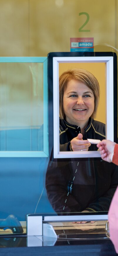 Eine Skifahrerin beim Ticketkauf an der Planai Talstation | © Harald Steiner - Fotografie