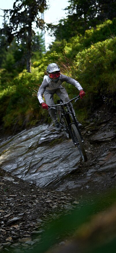 Downhill-Biker meistert eine steile Felssektion auf der Pro Downhill Strecke im Bikepark Schladming. | © Dietmar Koerbler