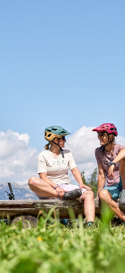 Mountainbikerinnen mit Helm und Sonnenbrille bei einer Pause im Bikepark Schladming. | © Dietmar Koerbler