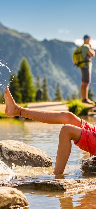 Kind sitzt am Teich in der Hopsi Kinderland Wasserwelt | © Christine Höflehner
