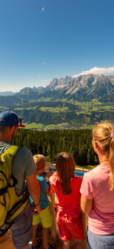 Familie von hinten fotografiert die auf ein Bergpanorama Blicken. | © Christine Höflehner