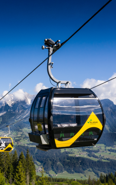 Zwei Gondeln der Planai sind im Vordergund zu sehen, hinten ist blauer Himmel. | © Josh Absenger