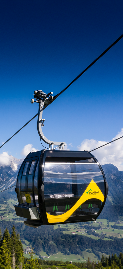 Zwei Gondeln der Planai sind im Vordergund zu sehen, hinten ist blauer Himmel. | © Josh Absenger