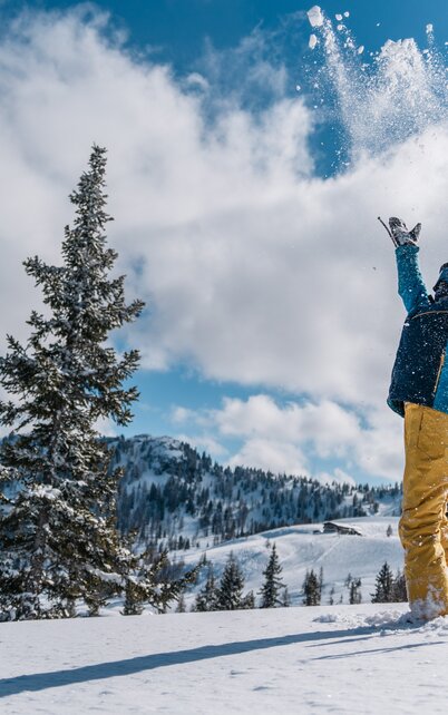 Kind wirft mit den Händen Schnee in die Luft. | © Gerald Grünwald