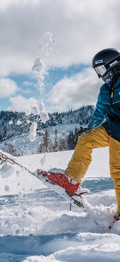 Kind wirft mit dem Ski Schnee in die Luft. | © Gerald Grünwald