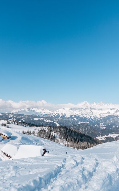 Kind steht im Tiefschnee und schaut auf die Landschaft rund um die Fageralm. | © Gerald Grünwald