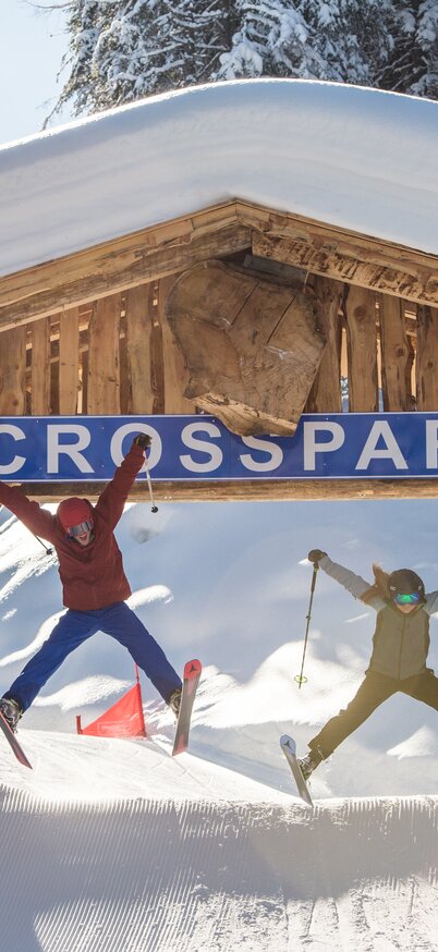 2 Skifahrer springen gerade durch die Hütte vom Crosspark Reiteralm durch. | © Lorenz Masser