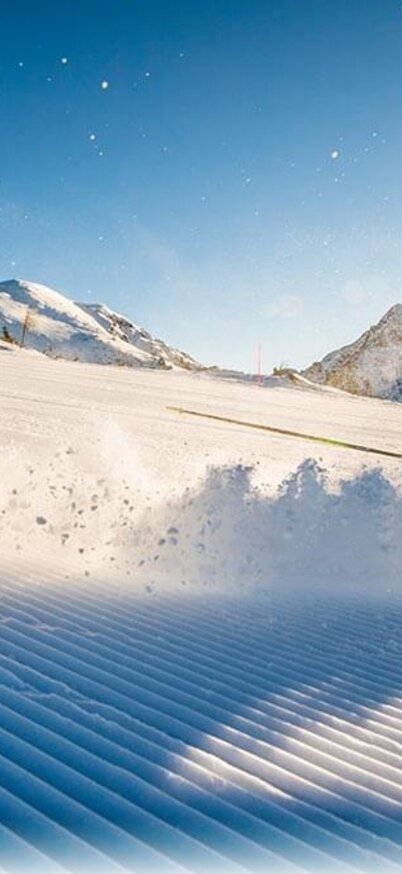 Mann fährt einen schnellen Scheung auf einer  frisch präparierten Piste der Reiteralm. | © Lorenz Masser