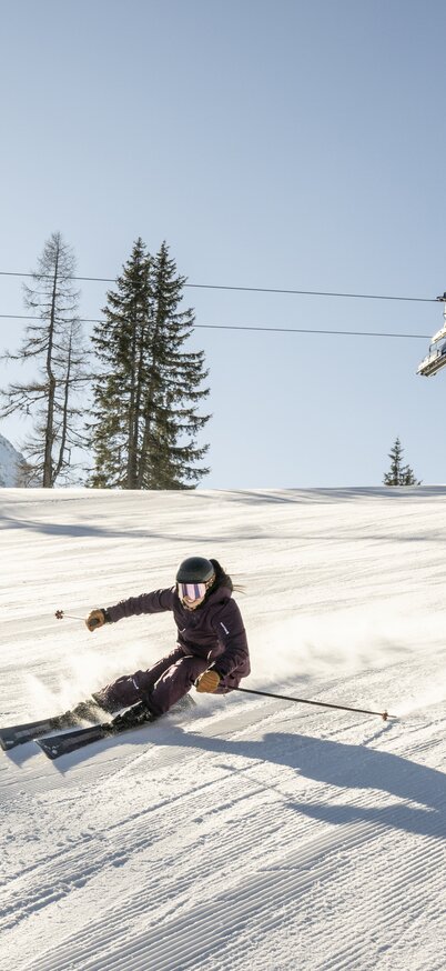 Skifahrer fährt im Sonnenschein die bestens präparierten Pisten der Reiteralm hinunter. | © Lorenz Masser
