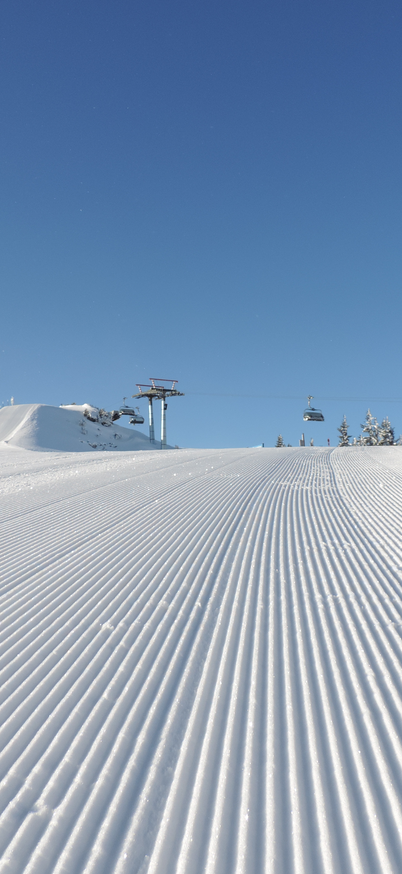 Eine frisch präparierte Piste der Reiteralm und im Hintergrund eine Liftstation. | © Reiteralm Bergbahnen