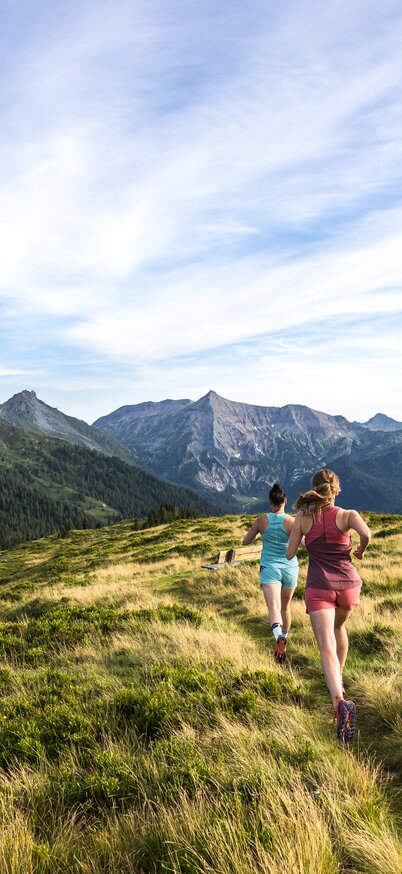Trailrunning auf dem Roßfeld in Rohrmoos, Schladming, Steiermark, Österreich (Austria) | © Martin Huber Im Bild zwei Läuferinnen in Aktion auf dem Höhenweg zu den Giglachseen mit Blick in die Schladminger Tauern und zur markanten Steirischen Kalkspitze. | © Martin Huber