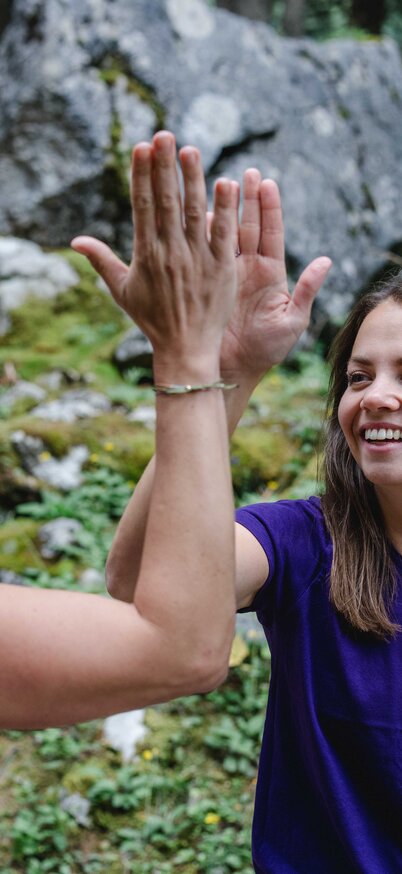 zwei lächelende Damen in der Freien Natur die sich abklatschen | © Indrich Fotografie