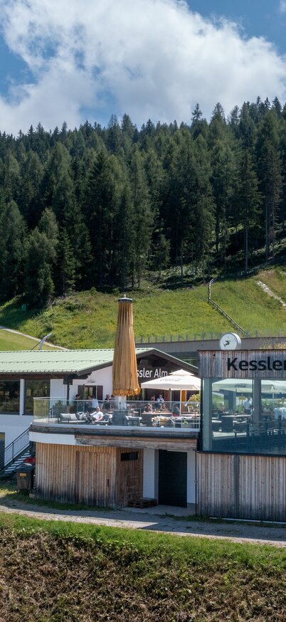 große Hütte mit modernen Touch mit großen Glasfenster und Sommerterasse | © Harald Steiner - Fotografie