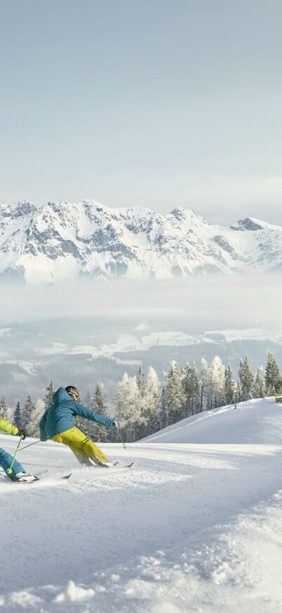 Zwei Personen ziehen Schwünge auf einer frisch präparierten Piste | © Peter Burgstaller