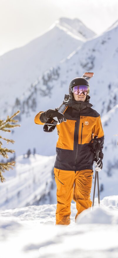 Skifahrer tragen Ski und lachen | © Mirja Geh