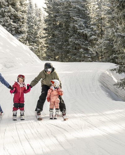 Familie fährt Ski in einer tief verschneiten Winterlandschaft | © Lorenz Masser