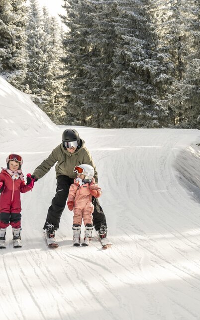 Familie fährt Ski in einer tief verschneiten Winterlandschaft | © Lorenz Masser