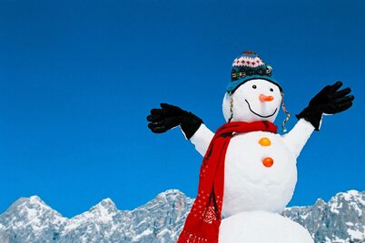 Schneemann vor der Kulisse des Dachstein-Massiv